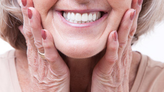 middle-aged woman smiling with dentures 