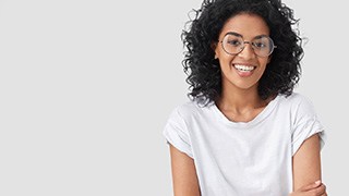 A young woman wearing a white blouse and smiling 